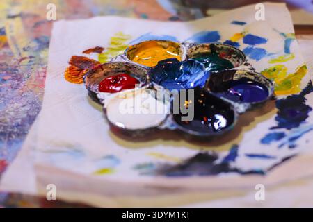 Farbenfrohe Farbpalette auf Papier, die kreatives Chaos und künstlerischen Ausdruck in einer lebendigen Komposition zeigt. Stockfoto