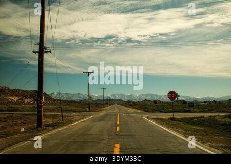 Ländliche Autobahnkreuzung mit Stoppschild und Bergkulisse in Kalifornien, USA Stockfoto