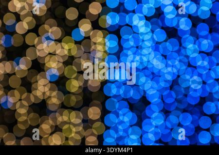 Blaue und goldene kreisförmige Bokeh-Lichter mit abstraktem Hintergrund schaffen einen luxuriösen Kontrast mit sanftem Glanz und modernem, professionellem Look. Stockfoto