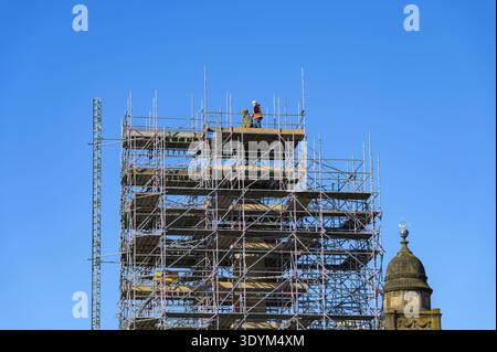 Eine Person, die auf dem Gerüst um die Sir Walter Scott Statue während der Renovierung am George Square, Glasgow, Schottland, Großbritannien, läuft Stockfoto