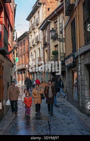 Fußgänger laufen durch eine enge, kopfsteingepflasterte Straße im historischen Stadtteil Barrio Húmedo in León, Spanien. Stockfoto