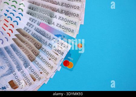 KIEW, UKRAINE - 28. JANUAR 2026 Schwedbank-Karte und schwedische Kronen-Geldscheine auf dem Tisch in Nahaufnahme. Swedbank ist die beliebteste Bank in Schweden Stockfoto