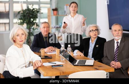 Der junge Mitarbeiter hält eine Präsentation für Führungskräfte im Büro Stockfoto