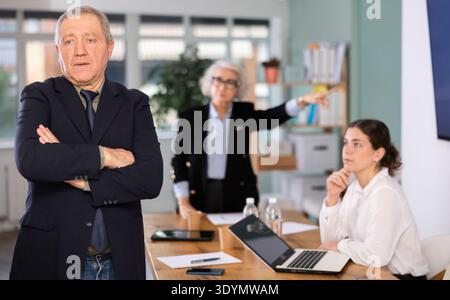 Ältere Frau schimpft älteren Mann im Amt Stockfoto