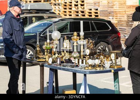 Antike Uhren, Vintage-Lampen und dekorative Objekte, die auf dem Flohmarkt im Freien in Polen, dem Flohmarkt in Osteuropa, zum Verkauf auf dem Tisch stehen. Stockfoto