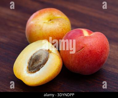Bild von köstlichen reifen Aprikosenfrüchten auf Holzoberfläche Stockfoto