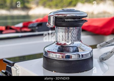 Nahaufnahme einer Segelwinde auf dem Deck einer Yacht, die die Metalltrommel und technische Details der Ausrüstung zeigt. Stockfoto