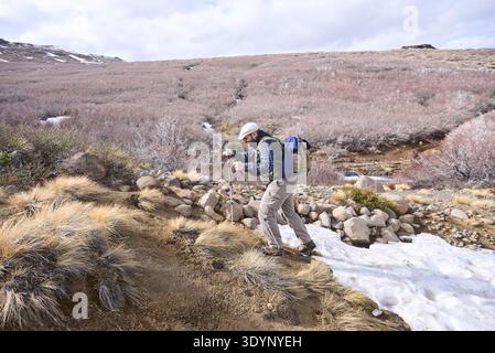 Männliche Wanderer, die im Winter durch die Berge wandern, durch eine schneebedeckte Gegend, in Caviahue, Nequen, Argentinien. Stockfoto
