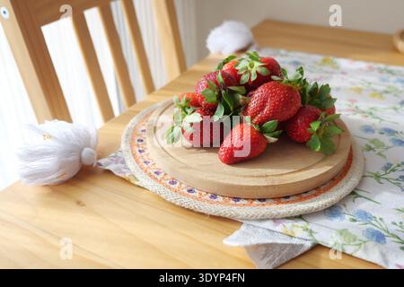 Erdbeeren auf einem Holzteller in einer hellen Küche Stockfoto