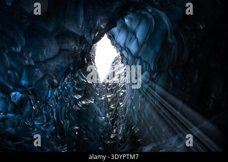 Blaues Gletschereis mit Sonnenlicht, das durch ein Loch in einer Eishöhle im Gletscher leuchtet. Breioarmerkurjokull, Teil des Vatnajokull-Gletschers im Südosten Stockfoto