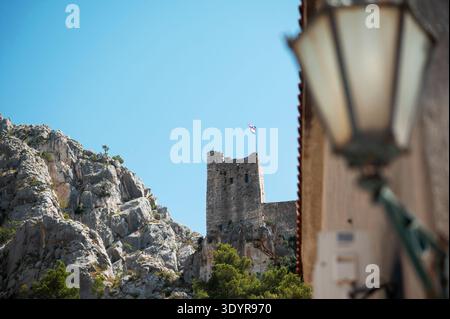 Die Ruinen der Festung Omis thronten auf einer felsigen Klippe unter einem klaren blauen Himmel Stockfoto