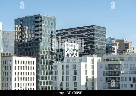 Der Blick auf moderne architektonische Gebäude mit unterschiedlicher Höhe und Design erhebt sich zum klaren blauen Himmel und zeigt eine Mischung aus Glas und Beton Stockfoto