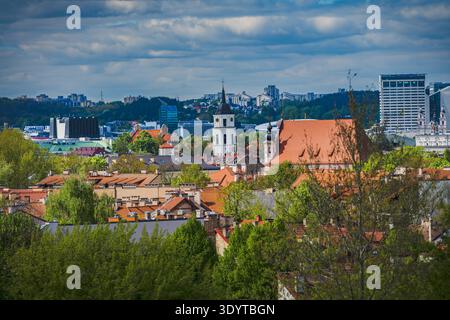 Panoramablick auf die Altstadt von Vilnius mit dem Glockenturm der St. Johns-Kirche und der Kathedrale des Theotokos unter einem bewölkten Himmel in Litauen. Stockfoto