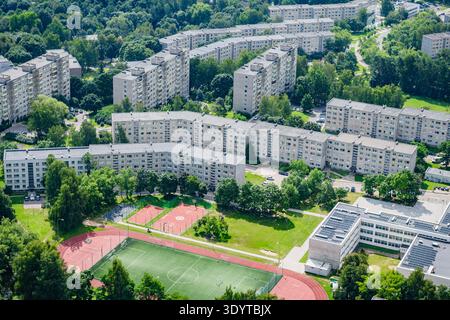 Aus der Vogelperspektive auf die Appartementblöcke aus der Sowjetzeit und einen modernen Sportkomplex mit einem Fußballfeld und Basketballfeldern in Vilnius, Litauen. Stockfoto
