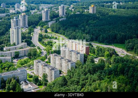 Aus der Vogelperspektive auf Wohnblocks aus der Sowjetzeit und üppige Kiefernwälder in den Stadtteilen Karoliniškės oder Lazdynai in Vilnius, Litauen. Stockfoto