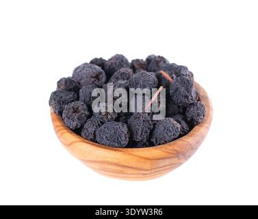 Getrocknete Aronia-Beeren, isoliert auf weißem Hintergrund. Trocknen Sie die schwarze Apfelbeere in einer Holzschale. Beschneidungspfad Stockfoto
