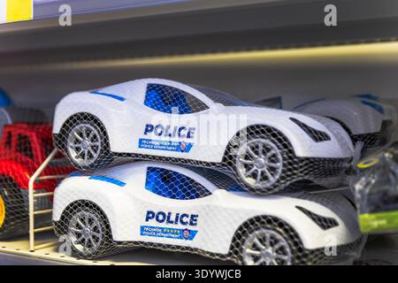 Spielzeug Polizeiautos in Schutzgitter in einem Ladenregal. Stockfoto