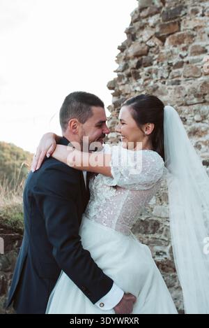 Der Bräutigam hebt und umarmt die Braut. Stockfoto