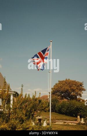 Die Flagge der Union Jack fliegt vor einem Haus in einem Küstenviertel in Worthing, West Sussex, England, Großbritannien. Stockfoto