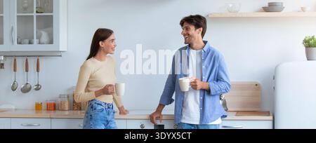 Freunde genießen Kaffee und teilen Gespräche in der modernen Küche während der Morgenstunden Stockfoto
