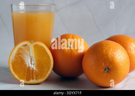 Komposition aus frischen Zitrusfrüchten und einem Glas natürlichen Orangensaft, perfekt für Ernährungs- und Wellnesskonzepte Stockfoto