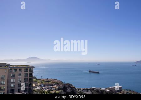 Schiffe fahren in der Nähe von Gibraltar über das Meer mit klarem Himmel und fernen Bergen im Blick Stockfoto