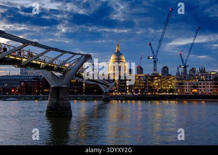 Dom der St. Paul's Cathedral und Millennium Bridge über die Themse in der Abenddämmerung mit der Skyline von London, London, England, Großbritannien Stockfoto