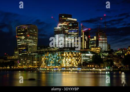 Skyline der Stadt London und beleuchtete Wolkenkratzer, die bei Nacht in der Themse reflektieren, London, England, Großbritannien Stockfoto