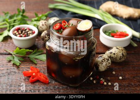 Eingelegte Wachteleier und Zutaten auf Holztisch, Nahaufnahme Stockfoto