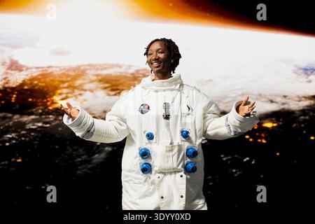 Fröhlicher Orbitalstation Astronaut begeistert von der Schönheit des Planeten im Weltraum. Fröhliche afroamerikanerin, die während einer planetaren Forschungsmission die Himmelskörper der Galaxie bewundert Stockfoto