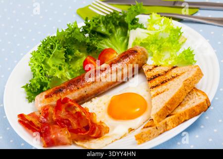 Spiegeleier mit Speck, Wurst, Brot Stockfoto