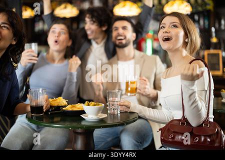 Gruppe von emotionalen jungen Freunden Unterstützer jubeln für Lieblingsteam feiert Sieg mit Gläsern Alkohol in Bier Pub Stockfoto