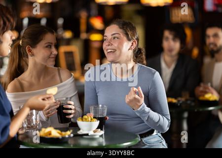 Glückliche Freundinnen haben Spaß und trinken Bier auf einer Party in der Bar Stockfoto