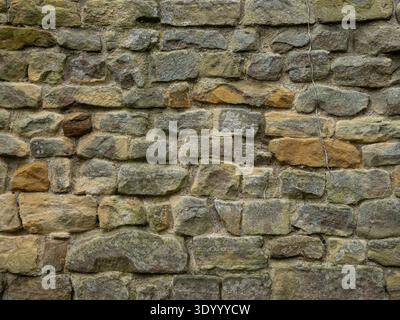 Alte Kalksteinblockwand mit Natursteingemauern Stockfoto