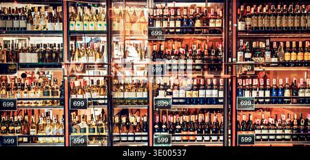 Panorama-Weinschau mit Festpreisen – erschwingliche Auswahl an Rot-, weiß- und Schaumweinen für 399, 599, 699 THB in einer modernen urbanen Weinbar Stockfoto