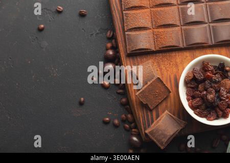 Zerquetschte Schokoladenstücke und Rosinen auf grauem Hintergrund Stockfoto