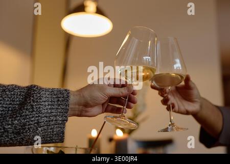 Kaukasische Männer und Frauen, die während des gesellschaftlichen Treffens Weingläser trinken Stockfoto