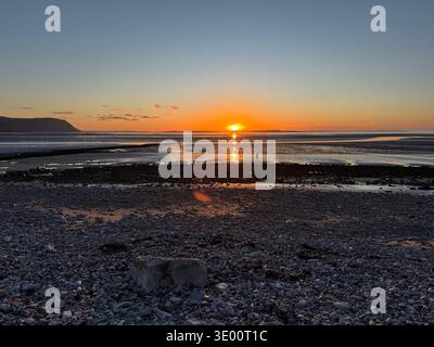 Dramatischer Sonnenuntergang, verstärkt durch einen Sahara-Staubsturm, der den Himmel in dunkles Gold, Bernstein und verbranntes Orange verwandelt. Llandudno Westküste Stockfoto