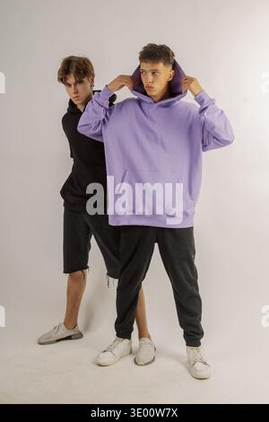 Zwei gutaussehende Typen mit Model-Aussehen posieren auf weißem Hintergrund in einem Fotostudio Stockfoto
