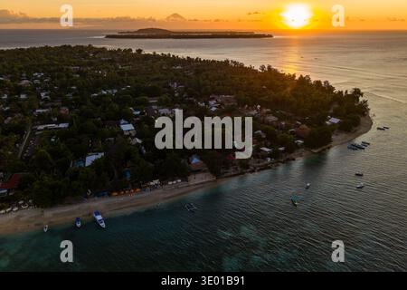 Wunderschöne Luftaufnahme eines tropischen Inseldorfes, Sandstrand und Boote bei Sonnenuntergang Stockfoto
