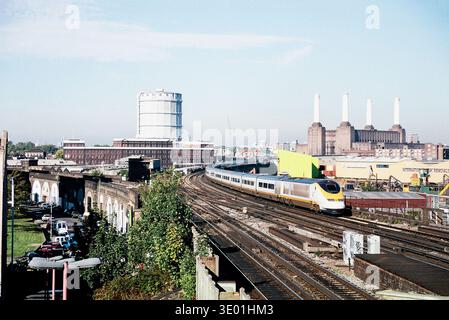 Der Zug der Eurostar-Klasse 373 nähert sich der Wandsworth Road und verlässt London im Jahr 1996, mit Battersea Power Station und einem Gashalter im Hintergrund. Der Eurostar-Dienst verkehrte auf alten Eisenbahnstrecken mit Standardgeschwindigkeiten vom Bahnhof London Waterloo International bis zum Channel Tunnel, bis die Hochgeschwindigkeitsstrecke 2007 fertiggestellt wurde. Die British Rail Class 373, in Frankreich als TGV TMST bekannt und von Eurostar als Eurostar e300 gebrandmarkt, war ursprünglich für den Betrieb auf dem dritten britischen Schienennetz wie hier geeignet. Schienenverbindung Stockfoto