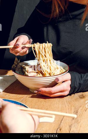 Mann isst Ramen mit Stäbchen. Professionelle Studio-Leuchte Stockfoto