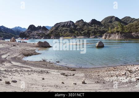 Bergsee mit felsiger Küste unter klarem Himmel Stockfoto
