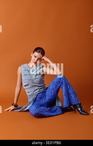 Stilvolle Frau sitzt anmutig in einem schicken Outfit, das moderne Modetrends unterstreicht. Stockfoto