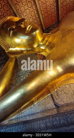 Nahaufnahme der liegenden goldenen Buddha-Statue mit detaillierter Handwerkskunst und symbolischem religiösen Ausdruck. Die Skulptur stellt Enlight dar Stockfoto