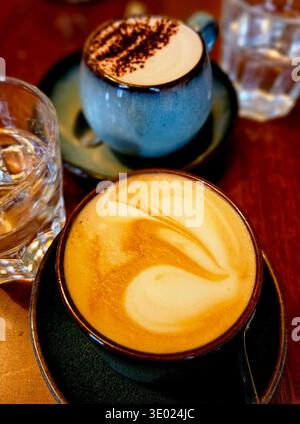 Cappuccino und heiße Schokolade in einem 3rd-Wave Café – Kaffeekultur mit handwerklichen Getränken, gemütliche Szene mit perfekt gefertigtem Cappuccino Stockfoto