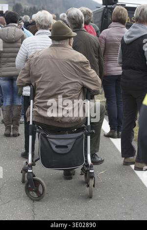 Rollator als Gehhilfe für den alten Mann in einer Gruppe von Menschen Stockfoto