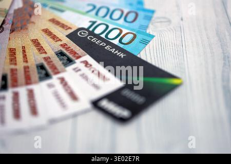 KIEW, UKRAINE - 28. JANUAR 2026 Sberbank-Karte und russische Rubel-Geldscheine auf dem Tisch. Sberbank ist die beliebteste Bank in Russland Stockfoto
