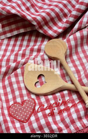 Kochlöffel auf farbenfrohem Küchentuch mit der Aufschrift „Cucina di Mama“ Stockfoto