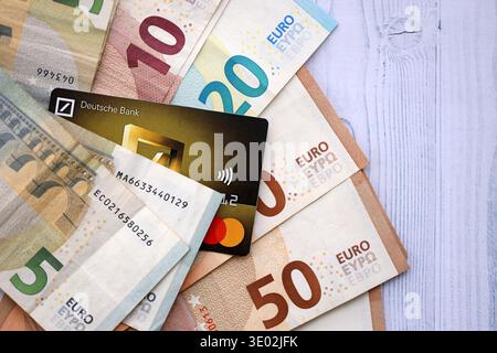 KIEW, UKRAINE - 28. JANUAR 2026 Deutsche Bank Karte und deutsche Euro-Geldscheine auf dem Tisch Nahaufnahme. Die Deutsche Bank ist die beliebteste Bank in Deutschland Stockfoto